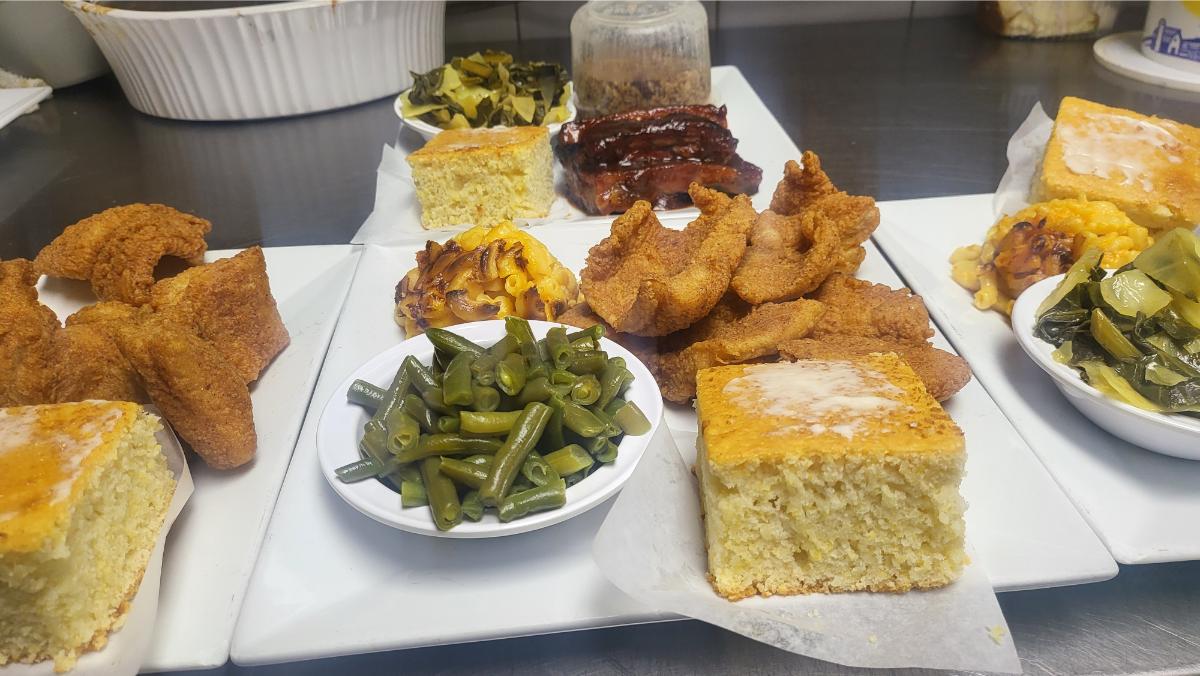 Soul food platters with fried fish, collard greens, mac and cheese, and cornbread at Soul Food Factory in Union, NJ